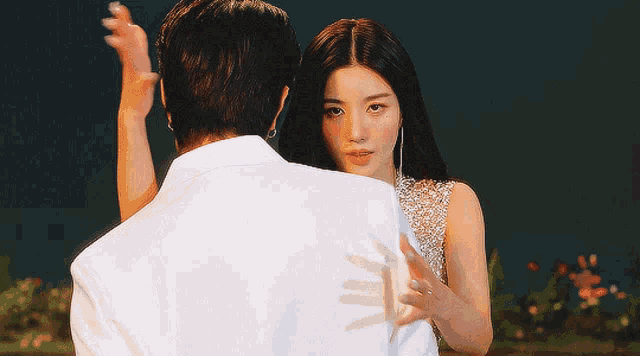 a woman with white nails is hugging a man in a white shirt
