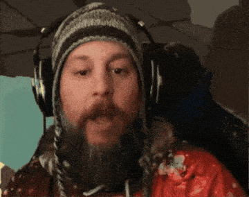 a man with a beard wearing headphones and a hat