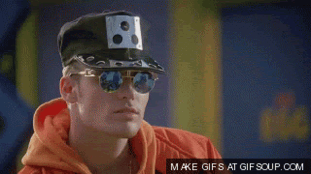 a man wearing sunglasses and a hat with the word what on it
