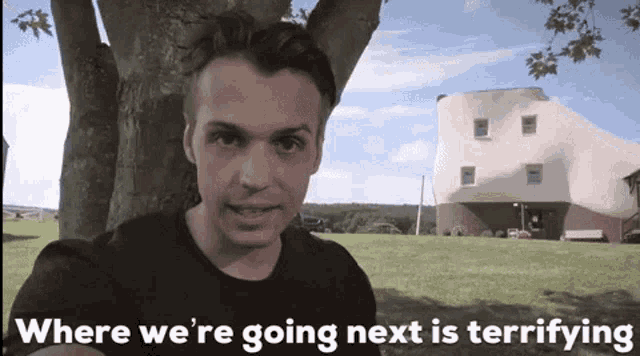 a man stands in front of a tree with the words where we 're going next is terrifying
