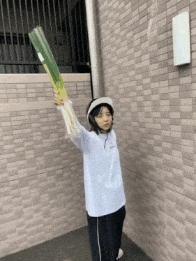 a person holding a very long green vegetable