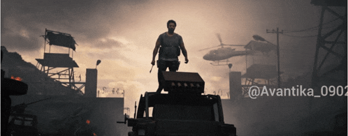 a man is standing on top of a vehicle with a helicopter in the background and the hashtag @avantika_0902