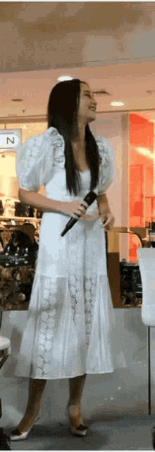 a woman in a white dress holding a microphone