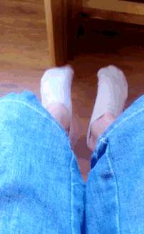 a person wearing white socks and blue jeans is sitting on the floor