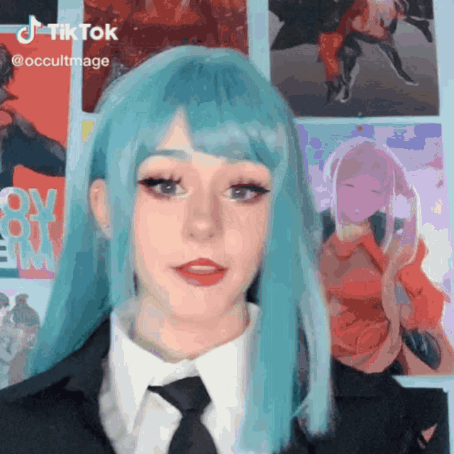 a woman with blue hair is wearing a suit and tie and has a tiktok account