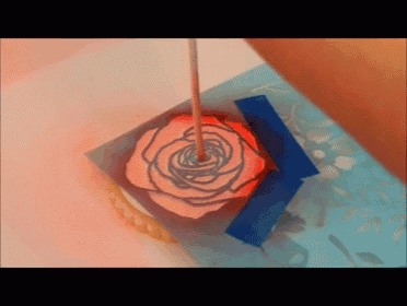 a drawing of a rose on a piece of paper with a blue tape around it