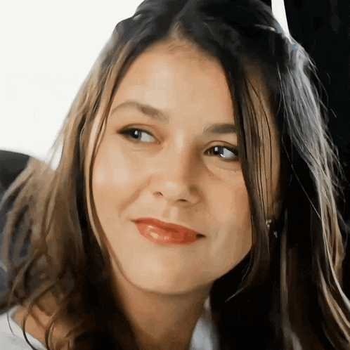 a close up of a woman 's face with a slight smile on her face