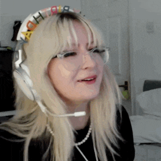 a woman wearing headphones and a headband with the word birthday on it is making a funny face .