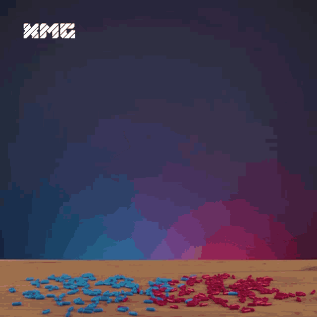 a man wearing sunglasses is sitting at a table with pills on it and a xmg logo behind him