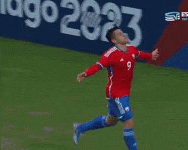 a man in a red jersey with the number 9 on it high fives another man