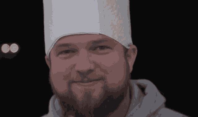 a man with a beard and a paper towel hat on his head