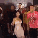 a woman in a white dress is standing in front of a group of men .