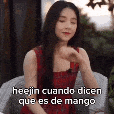 a woman in a red dress is sitting in a chair with her eyes closed and says hee jin cuando dicen que es de mango