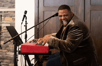 a man is playing a red keyboard in front of a microphone .