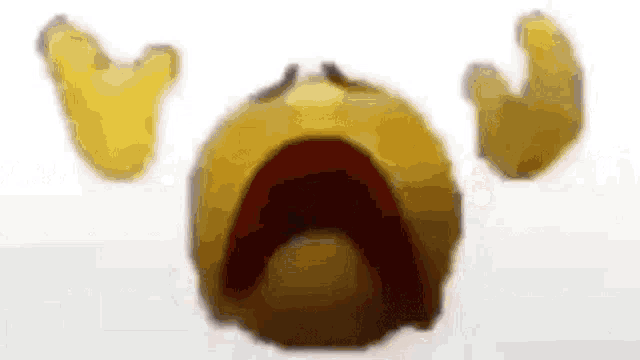a close up of a yellow smiley face with its mouth open and tears coming out of it .