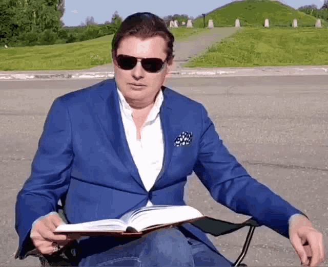 a man in a blue suit is reading a book
