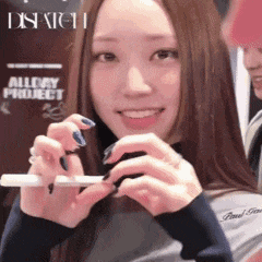 a woman is holding a cell phone in front of a sign that says dispatch