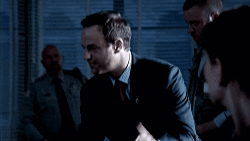 a man in a suit and tie stands in front of a group of men