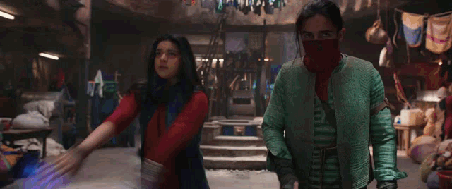 a man and a woman are fighting in a room and the woman is holding a purple object in her hand .