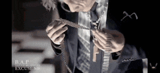 a man in a suit and tie is holding a necklace that says bap japan
