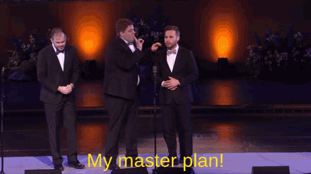 a group of men in tuxedos on a stage with my master plan written on the bottom