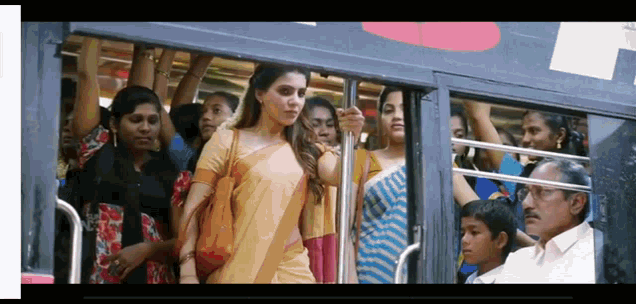 a woman in a saree is standing on a bus