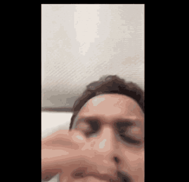 a close up of a man 's face with his eyes closed .