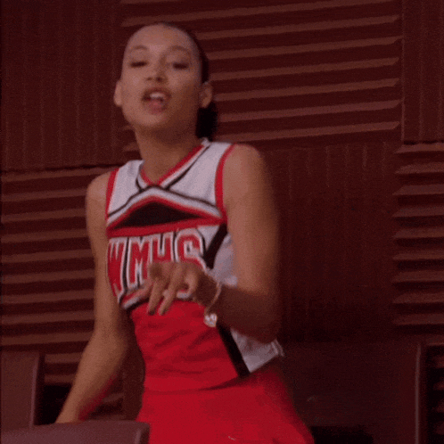 a cheerleader wearing a wmhs uniform is pointing at something