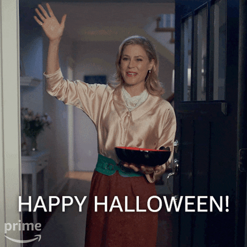 a woman holds a bowl in her hand and says " happy halloween "