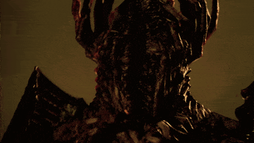 a close up of a monster 's face with a few hands on it