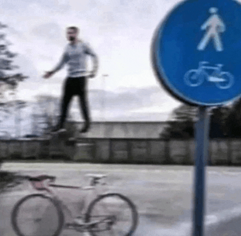a man is riding a bike next to a blue sign that says pedestrians and bicycles