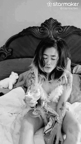 a black and white photo of a woman holding a wine glass with the starmaker id 13375167941