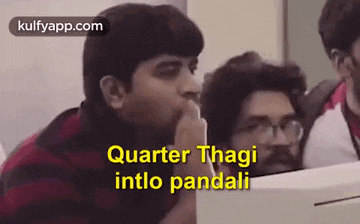 a group of men are sitting in a room and one of them is talking to the other .