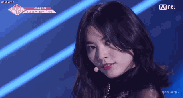 a woman singing into a microphone with the word mnet on the bottom left