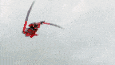 a red object is being thrown in the air by a person