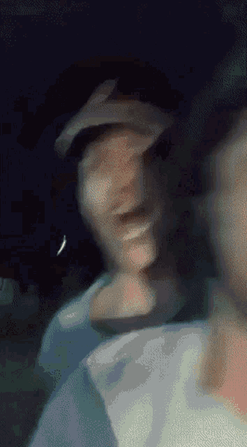 a blurry picture of a man wearing a hat and smiling