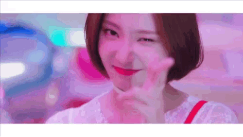 a woman with short hair is making a peace sign .