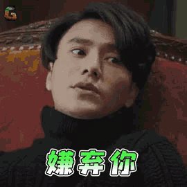 a man in a black turtleneck is sitting in a chair with chinese characters on his face .