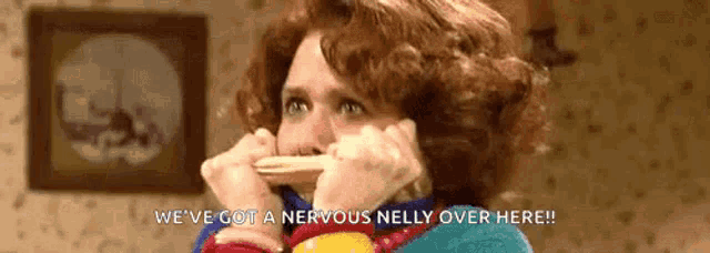 a woman is covering her mouth with her hands and saying `` we 've got a nervous nelly over here '' .