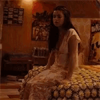 a woman in a white dress is standing in front of a box of nina 's ice cream .