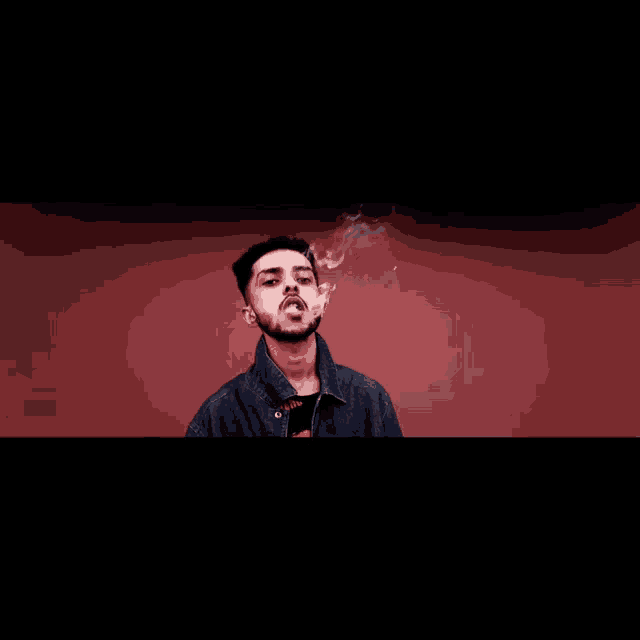 a man with a beard is smoking a cigarette against a red wall .