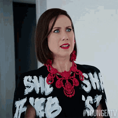 a woman wearing a black shirt that says she 's free is making a funny face .
