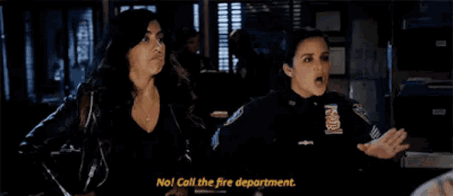 two women are standing next to each other in a room and one of them is talking to the other .
