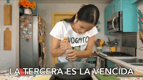 a woman in a t-shirt that says vogato is cooking