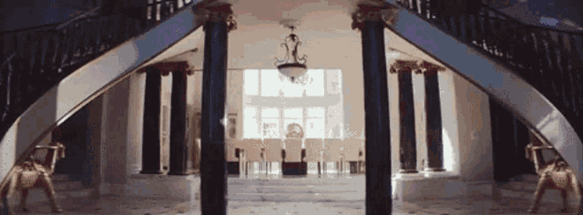 a large staircase in a house with columns and a chandelier