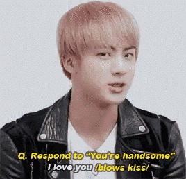 a young man with pink hair is wearing a leather jacket and a white shirt and says `` i love you blows kiss '' .