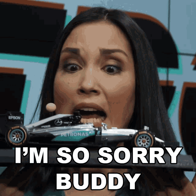a woman is holding a toy petronas race car in her mouth