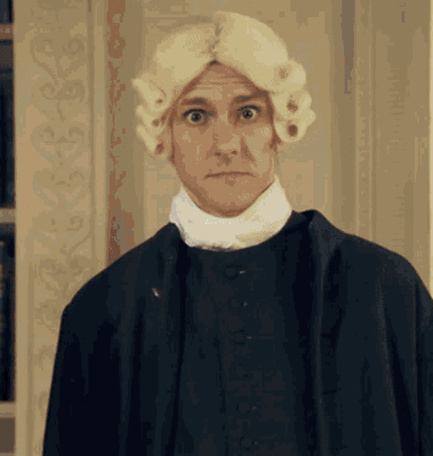 a man wearing a wig and a black coat