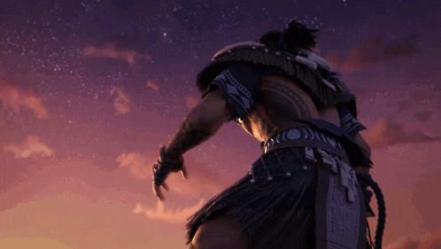 a man with a tattoo on his back is standing in front of a purple sky