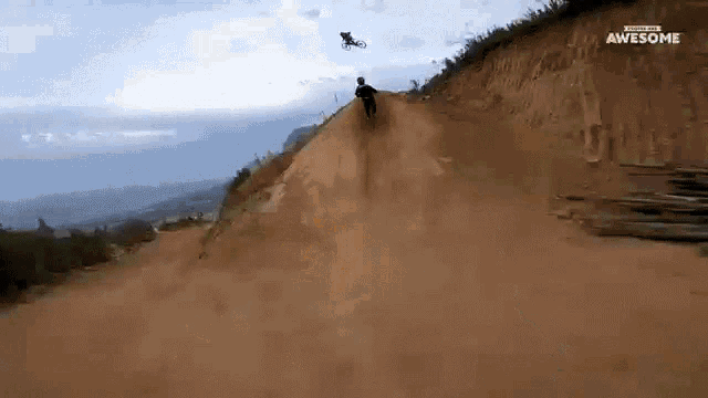 a man is riding a bike down a dirt hill and the words awesome are on the bottom of the screen